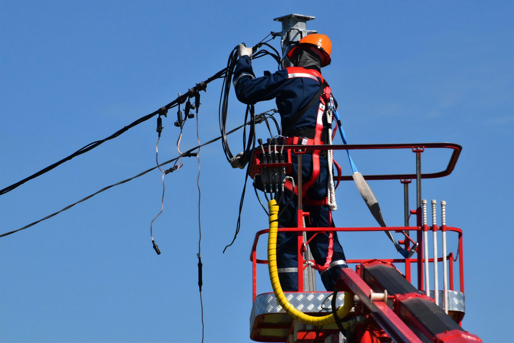Operario en plataforma elevadora ejecutando obra eléctrica de media tensión en líneas aéreas - Sinergia Servicios